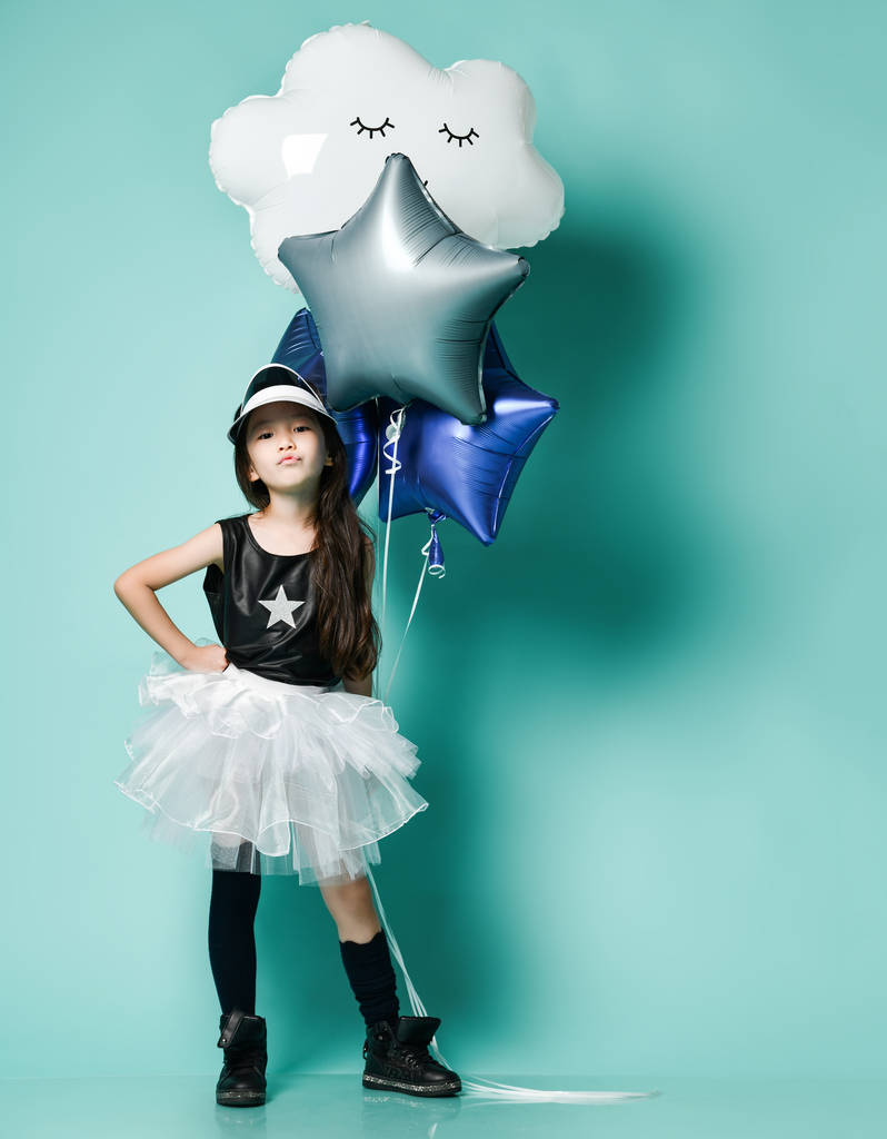Happy fashion asian girl hold bunch of big helium balloons celebrate birthday on blue  - Photo, Image