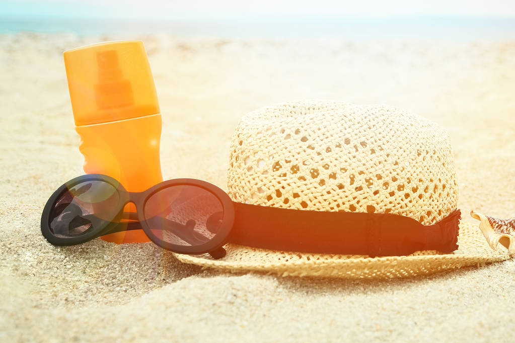 hermoso sombrero con gafas y crema en el mar en la arena de nuevo
 - Foto, Imagen