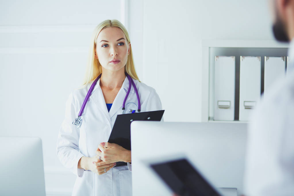 Femme médecin debout avec dossier à l'hôpital - Photo, image
