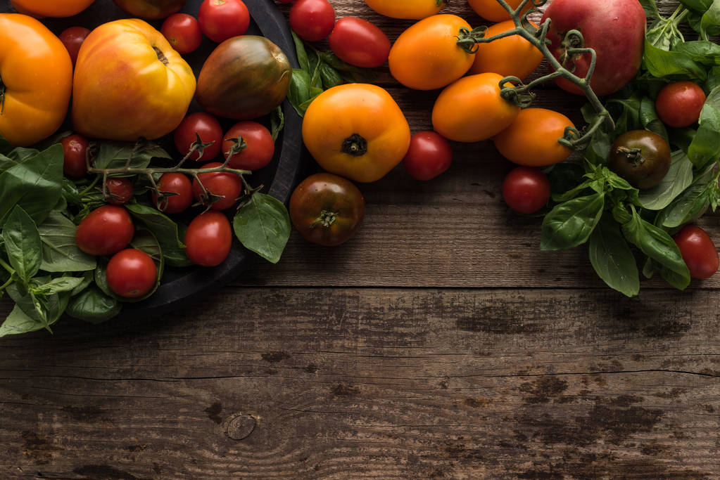 vista superior de tomates espalhados perto de tomates e espinafre na panela de pizza na mesa de madeira
  - Foto, Imagem