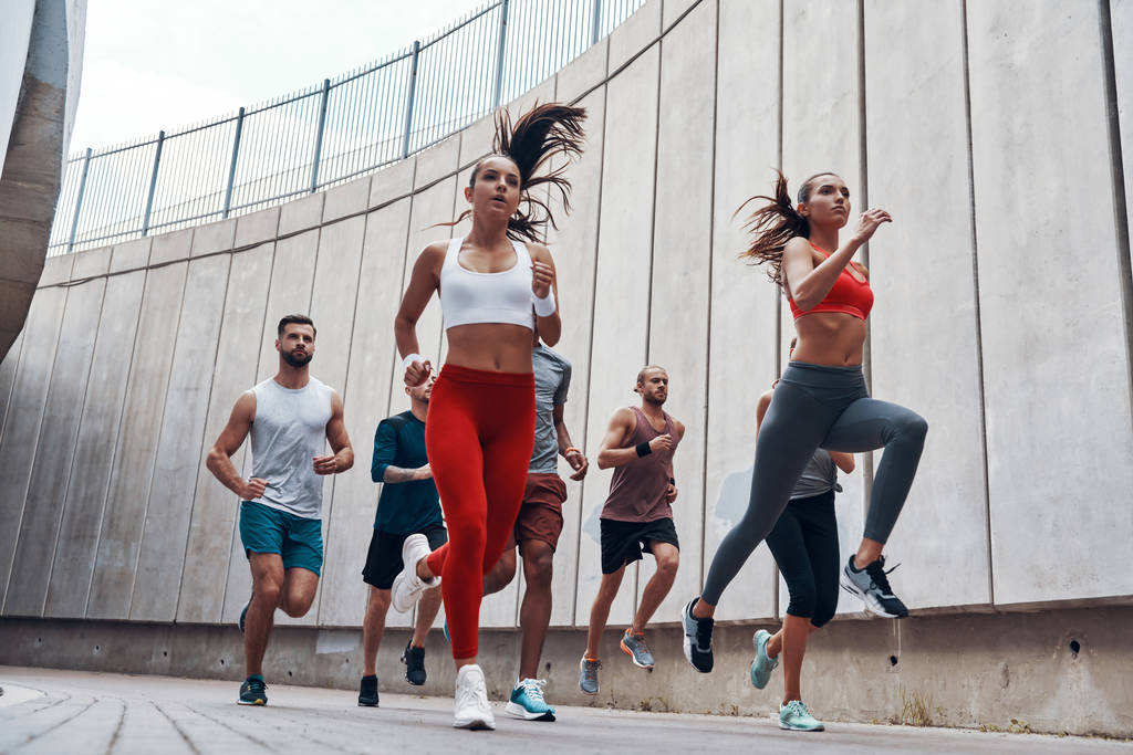 pessoas esportivas em roupas esportivas correndo ao ar livre na parede
 - Foto, Imagem