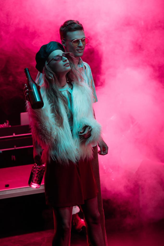 beautiful young woman with beer and man in nightclub during rave - Photo, Image