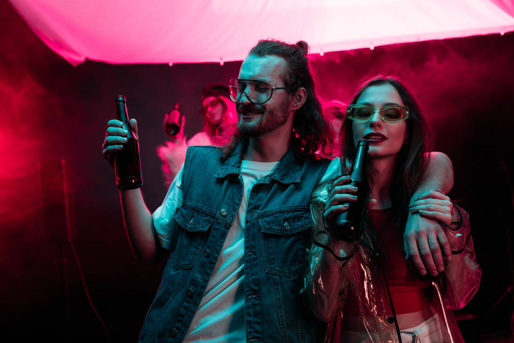 bella giovane donna e bell'uomo con birra in discoteca durante il rave
 - Foto, immagini