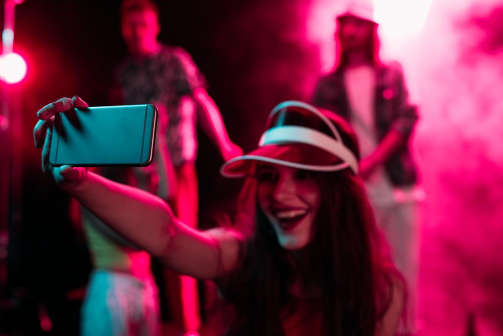 šťastné děvče, které se při večírku v nočním klubu spřátelit na smartphone - Fotografie, Obrázek