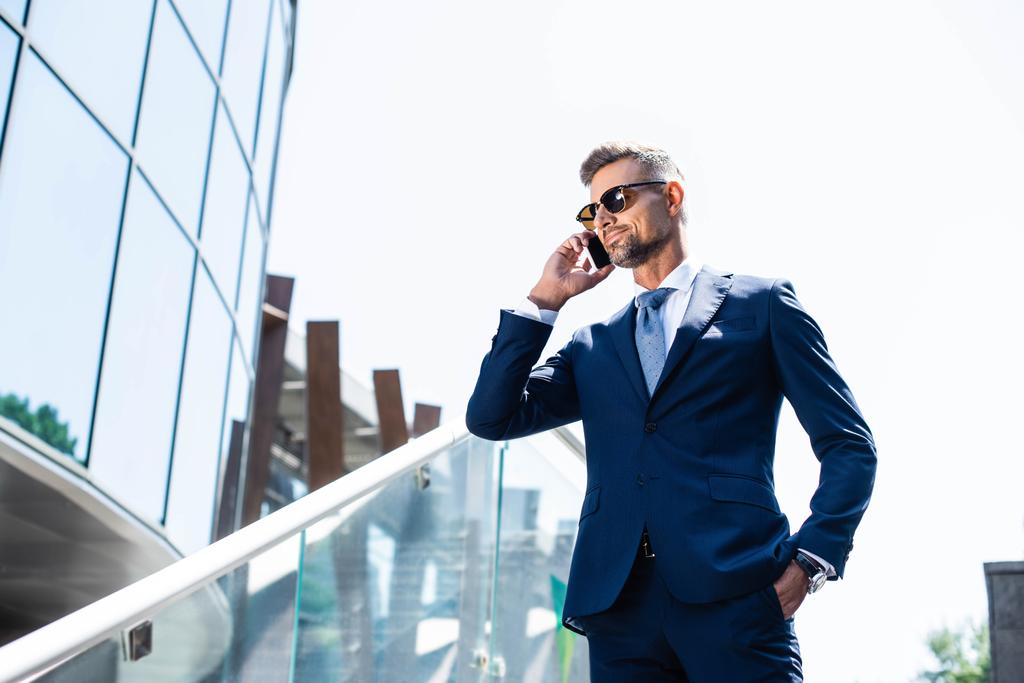 handsome man in suit with hand in pocket talking on smartphone  - Photo, Image