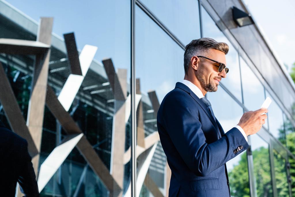side view of handsome man in suit and glasses using smartphone  - Photo, Image