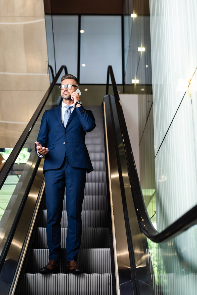 bel homme d'affaires en costume et lunettes parlant sur smartphone
  - Photo, image
