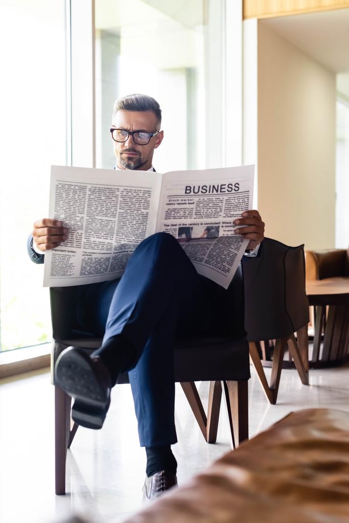 handsome businessman in suit and glasses reading newspaper business - Photo, Image
