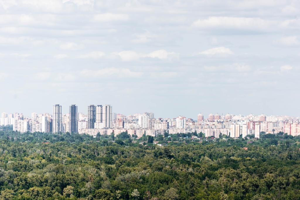 Urban scene with trees in city park, skyscrapers and buildings  - Photo, Image