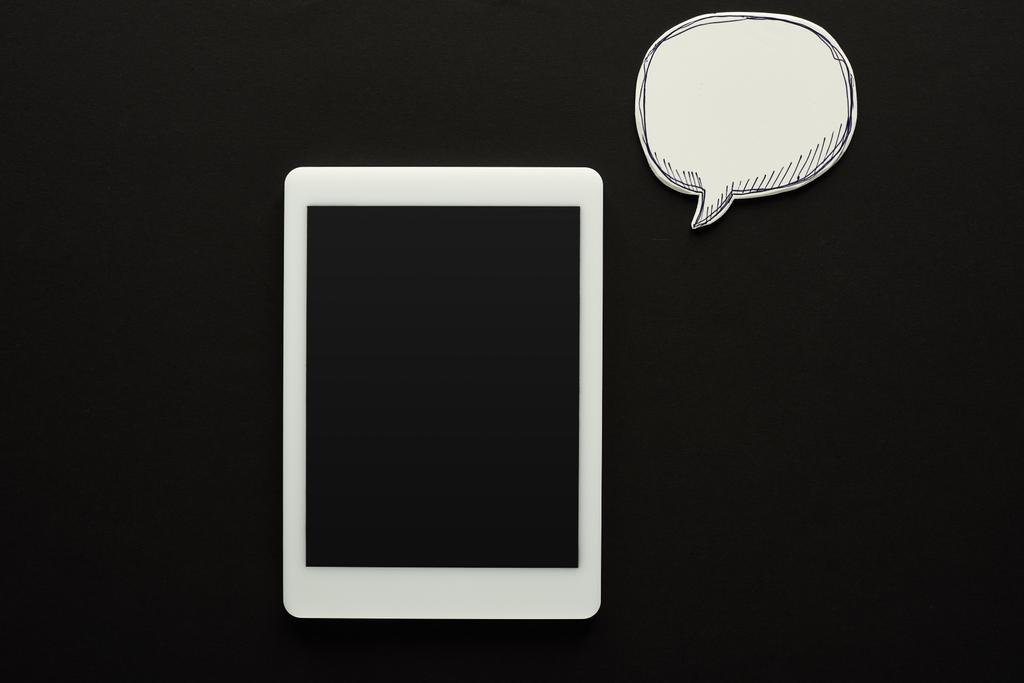 вид сверху цифрового планшета с пустым экраном на черном фоне рядом с пустым белым пузырём речи, концепция киберзапугивания
 - Фото, изображение