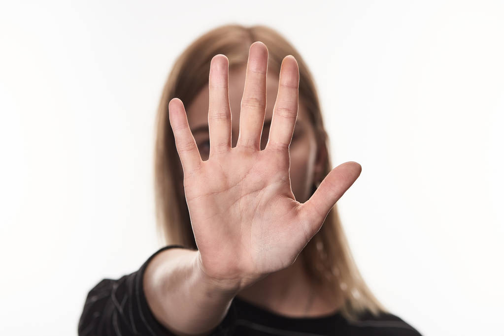 вибірковий фокус жіночої жертви знущань, що показують знак зупинки ізольовано на білому
 - Фото, зображення