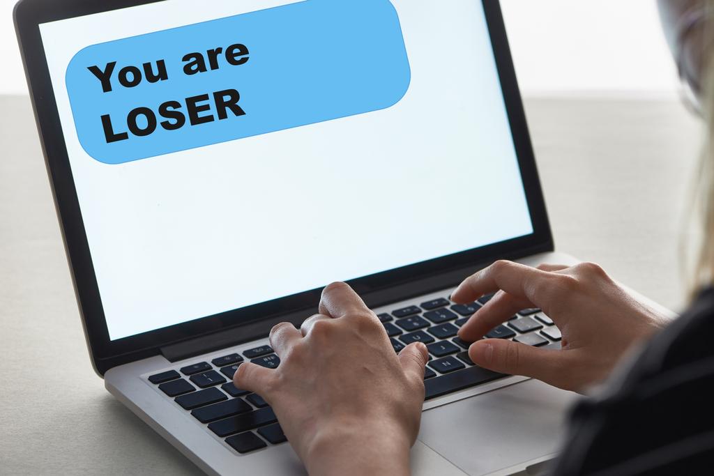 vista cortada de menina digitando no teclado do laptop com você são mensagem perdedora na tela, conceito de cyberbullying
 - Foto, Imagem