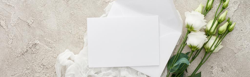 plano panorámico de tarjeta de invitación vacía en mantel de queso blanco cerca de flores eustoma en superficie texturizada
 - Foto, imagen