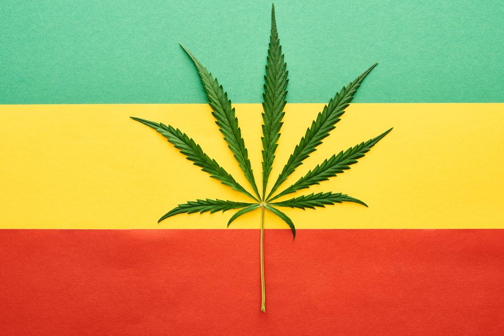Rastafarian bayrak arka plan üzerinde esrar yaprağı üst görünümü - Fotoğraf, Görsel