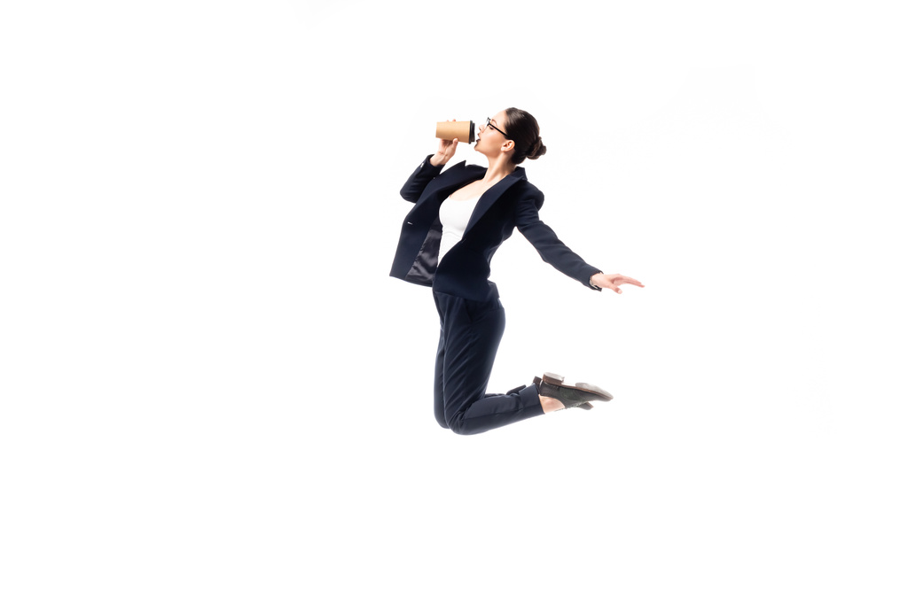jovem empresária beber café para ir enquanto dança isolado no branco
 - Foto, Imagem