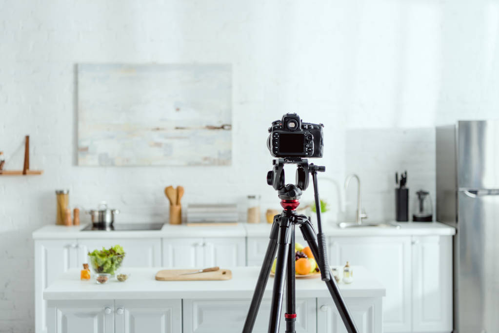 selective focus of digital camera on tripod in modern kitchen  - Photo, Image