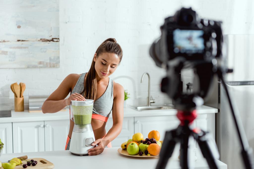 selective focus of cheerful woman preparing smoothie in blender  - Photo, Image