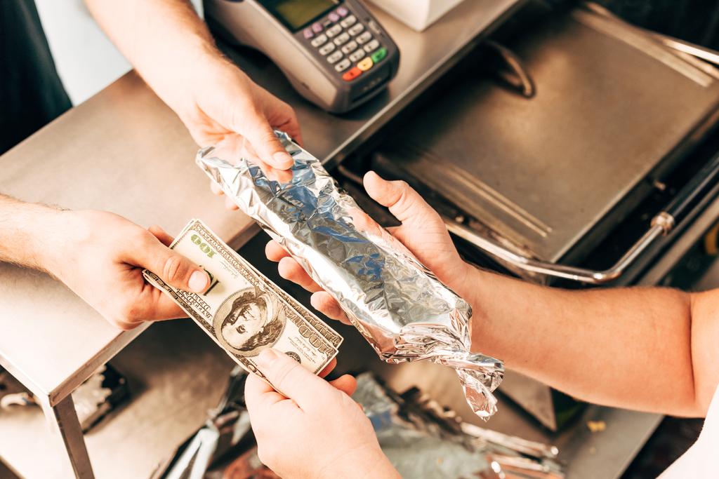 vista ritagliata di uomo acquisto doner kebab in foglio di alluminio
 - Foto, immagini