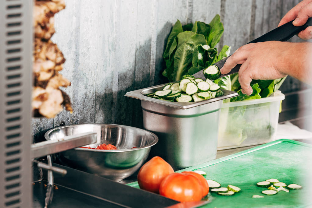 カット野菜とテーブルでナイフを保持する調理器具のトリミングビュー - 写真・画像