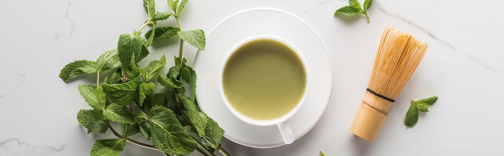Top uitzicht op groene Matcha thee met munt en Garde op witte tafel - Foto, afbeelding