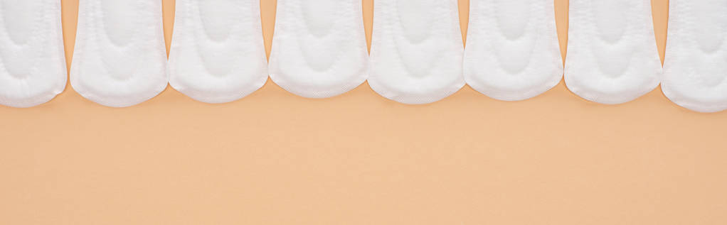 posa piatta con assorbenti igienici in cotone bianco isolati su colpo beige, panoramico
 - Foto, immagini