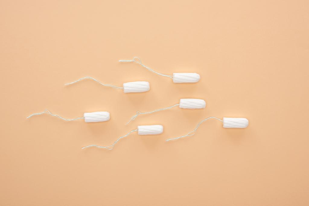 vista superior de tampones de algodón blanco aislados en beige
 - Foto, imagen