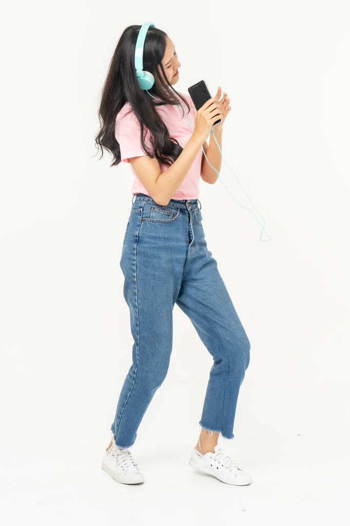Feliz asiática adolescente pasajero escuchando la música con auriculares
 - Foto, Imagen
