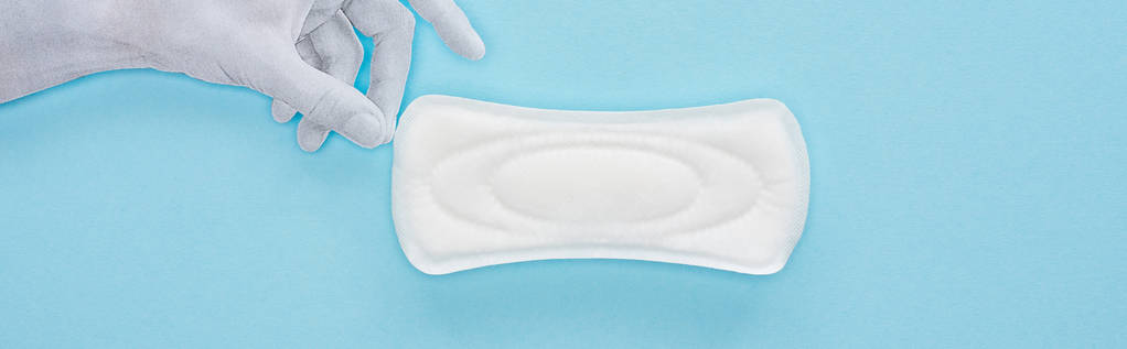 κορυφή θέα του λευκού χαρτιού χέρι κρατώντας βαμβακερό πετσέτα υγιεινής σε μπλε φόντο, πανοραμική βολή - Φωτογραφία, εικόνα