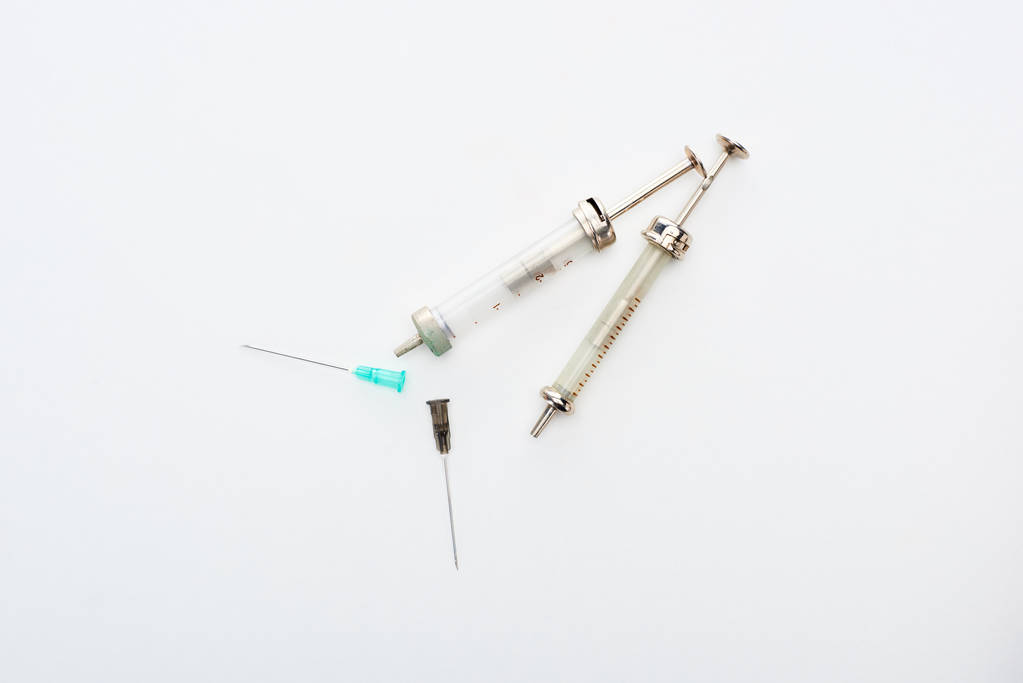 top view of aged syringes with needles on white background with copy space - Photo, Image