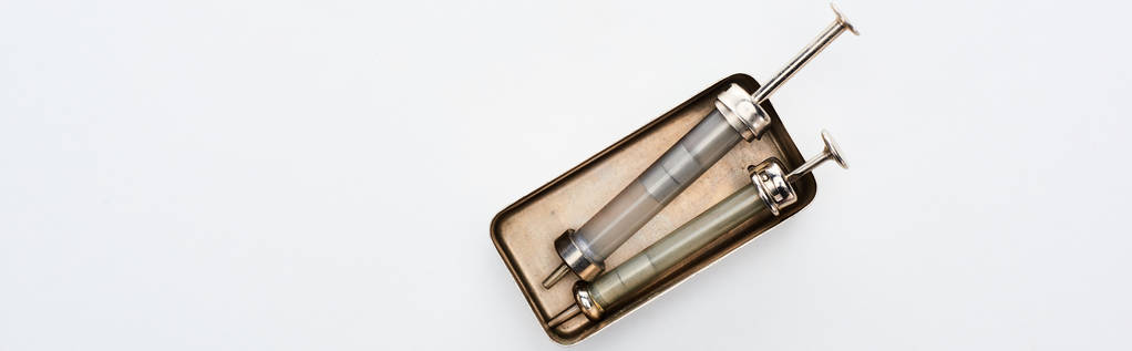 vista superior de seringas envelhecidas em caixa vintage em fundo branco com espaço de cópia, tiro panorâmico
 - Foto, Imagem