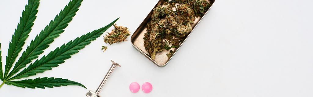 白い背景にマリファナの芽、大麻の葉、lsdと注射器のトップビュー、パノラマショット - 写真・画像