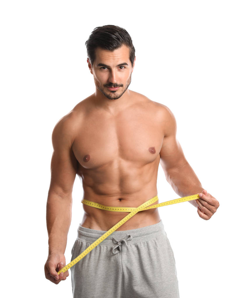 Beyaz arka planda ölçüm bandı kullanarak ince vücutlu genç adam - Fotoğraf, Görsel