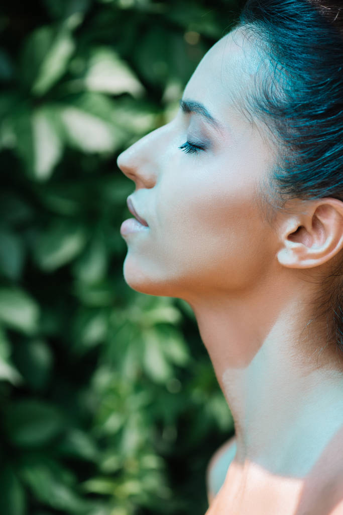 vista lateral de un rayo azul sobre una joven mujer desnuda con los ojos cerrados
  - Foto, imagen