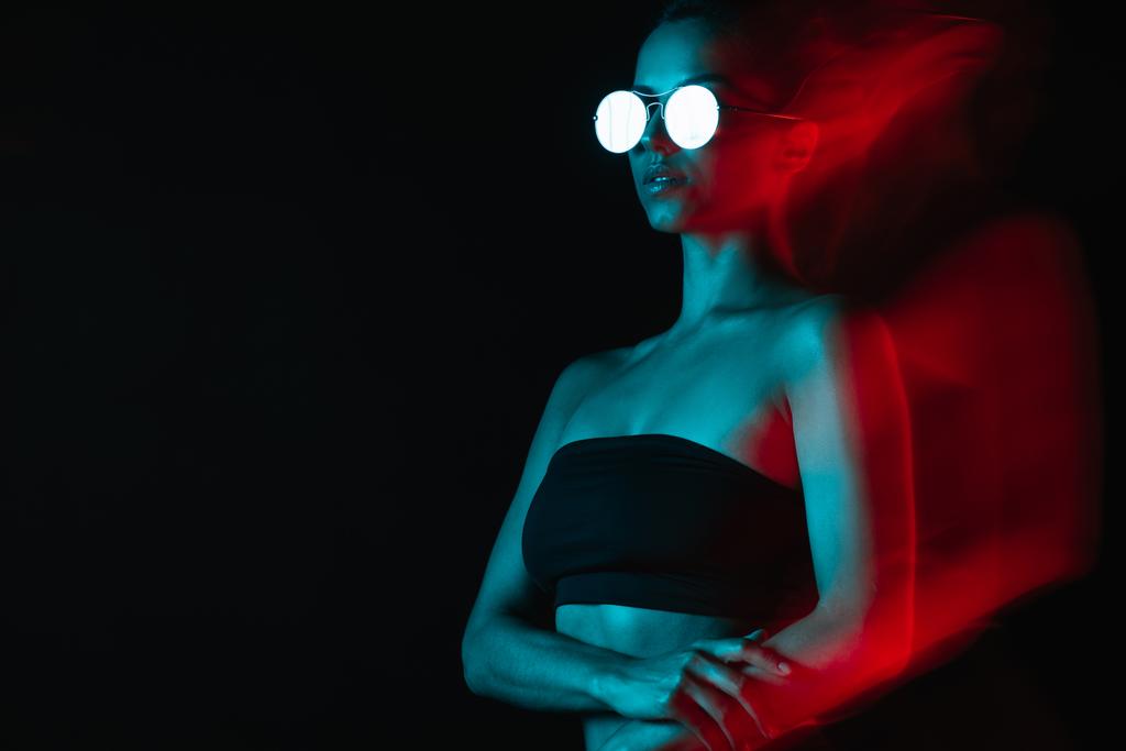 flou de mouvement de jolie femme en lunettes de soleil sur noir
  - Photo, image