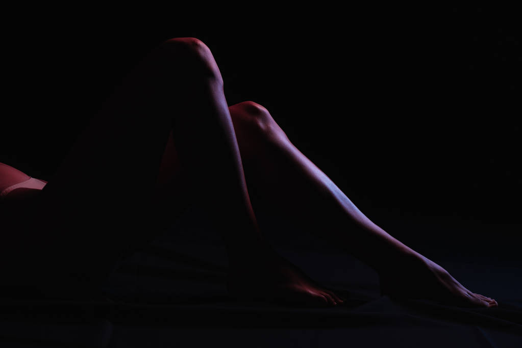 vista ritagliata della donna sdraiata isolata sul nero
  - Foto, immagini