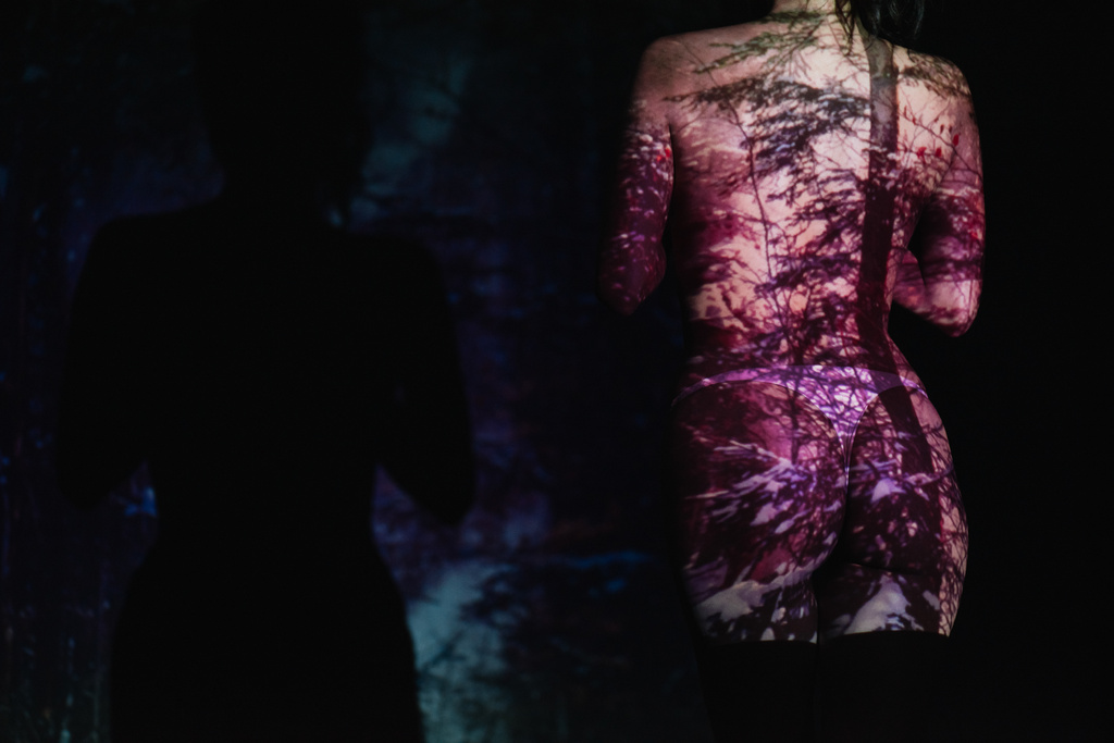 vista cortada de mulher jovem despida com sombras no corpo em pé no preto
  - Foto, Imagem