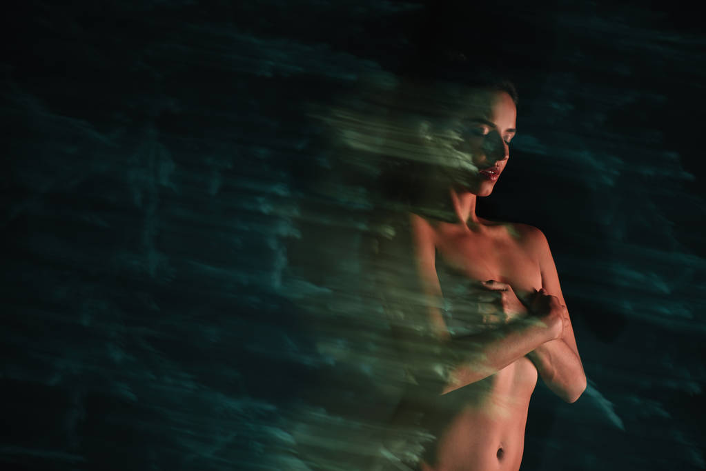 довге експонування оголеної дівчини, що стоїть і покриває груди на чорному
  - Фото, зображення