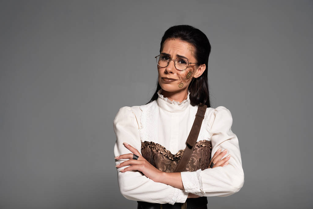 disappointed steampunk woman in glasses looking at camera isolated on grey - Photo, Image