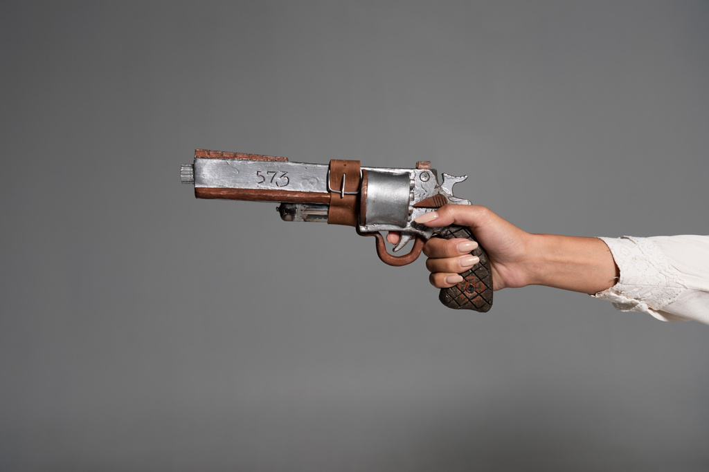 обрезанный вид женщины с винтажным пистолетом, изолированным на сером
 - Фото, изображение