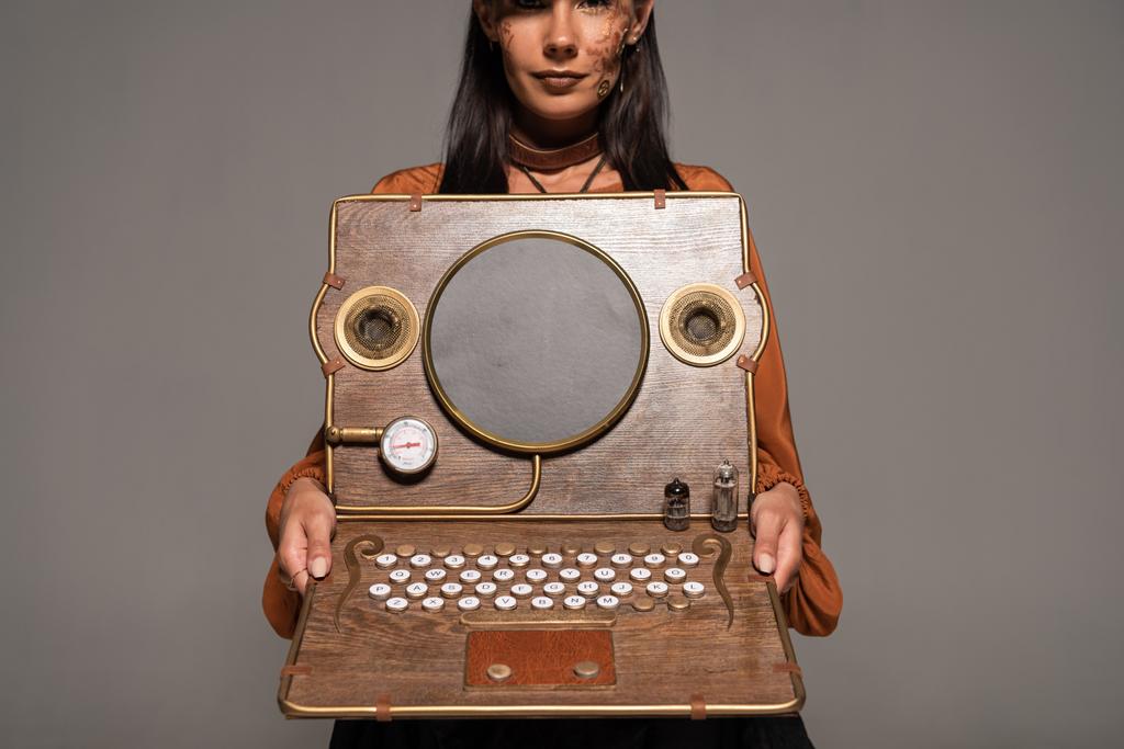 przycięte widok kobiety pokazano steampunk laptop na szaro - Zdjęcie, obraz