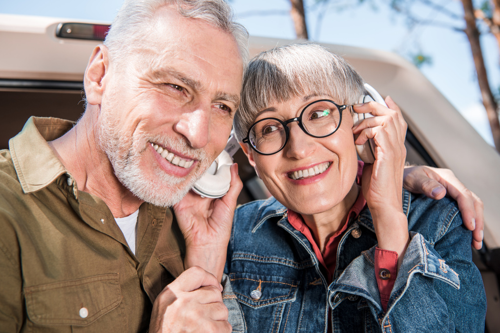усміхнена старша пара туристів слухає музику в навушниках
 - Фото, зображення