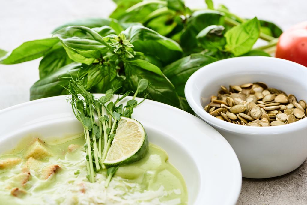 piatto di deliziosa zuppa di spinaci verdi cremoso con crostini, germogli di lime e semi di zucca
 - Foto, immagini