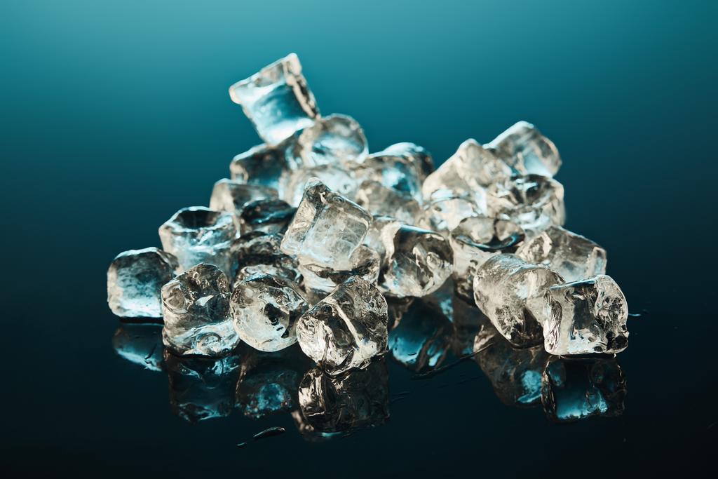 エメラルドの背景に透明な氷の立方体のスタック - 写真・画像