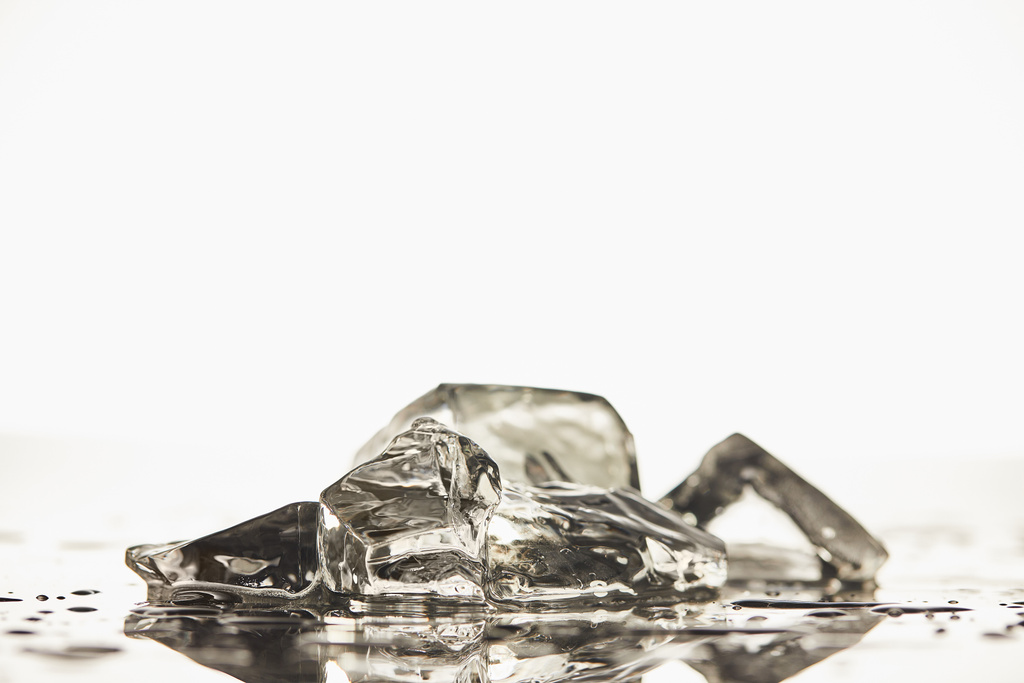 стопка прозорих розтоплених кубиків льоду на білому тлі
 - Фото, зображення