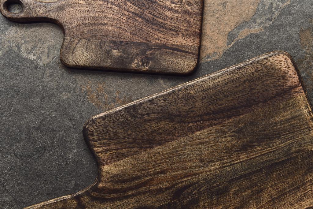 Draufsicht auf braune Holzschneidebretter auf verwittertem grauen Hintergrund - Foto, Bild