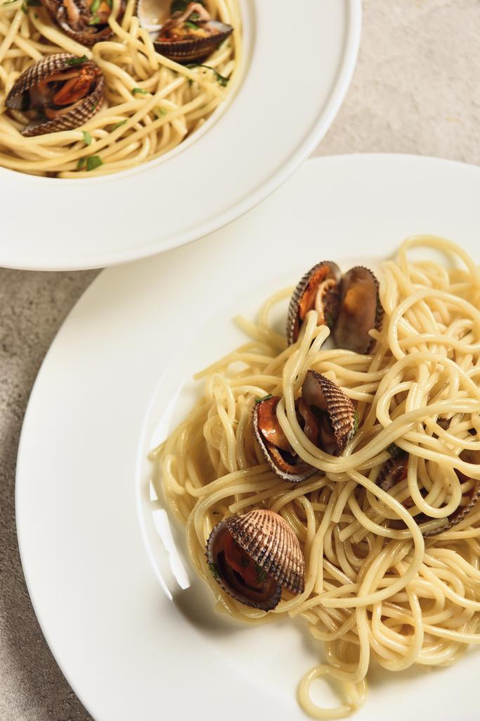 Nahaufnahme von köstlichen Pasta mit Meeresfrüchten serviert in zwei weißen Tellern - Foto, Bild