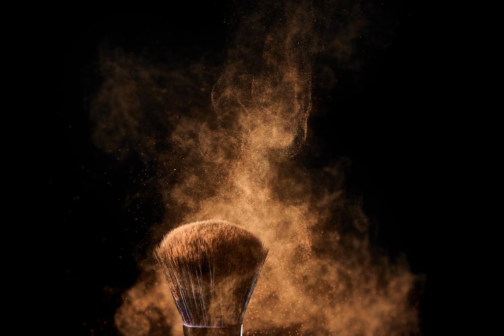 siyah arka plan üzerinde renkli altın toz patlama ile kozmetik fırça - Fotoğraf, Görsel