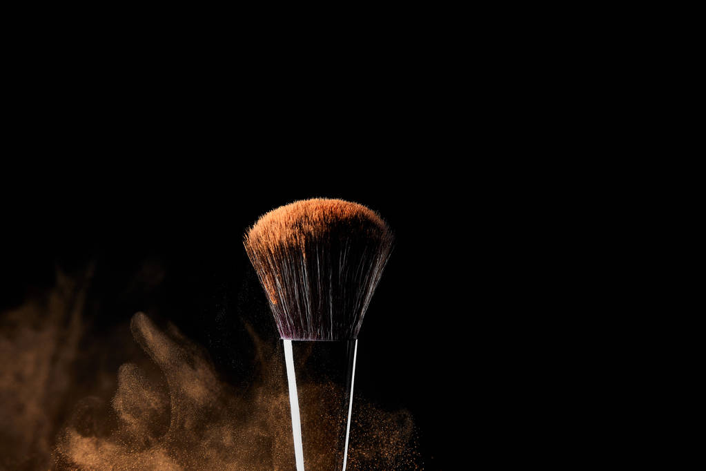 cosmetic brush with colorful golden powder on black background - Photo, Image