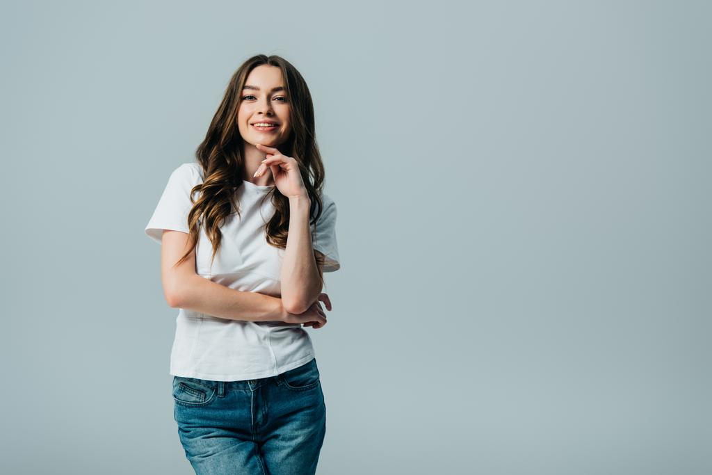 smiling beautiful girl in white t-shirt looking at camera isolated on grey - Photo, Image