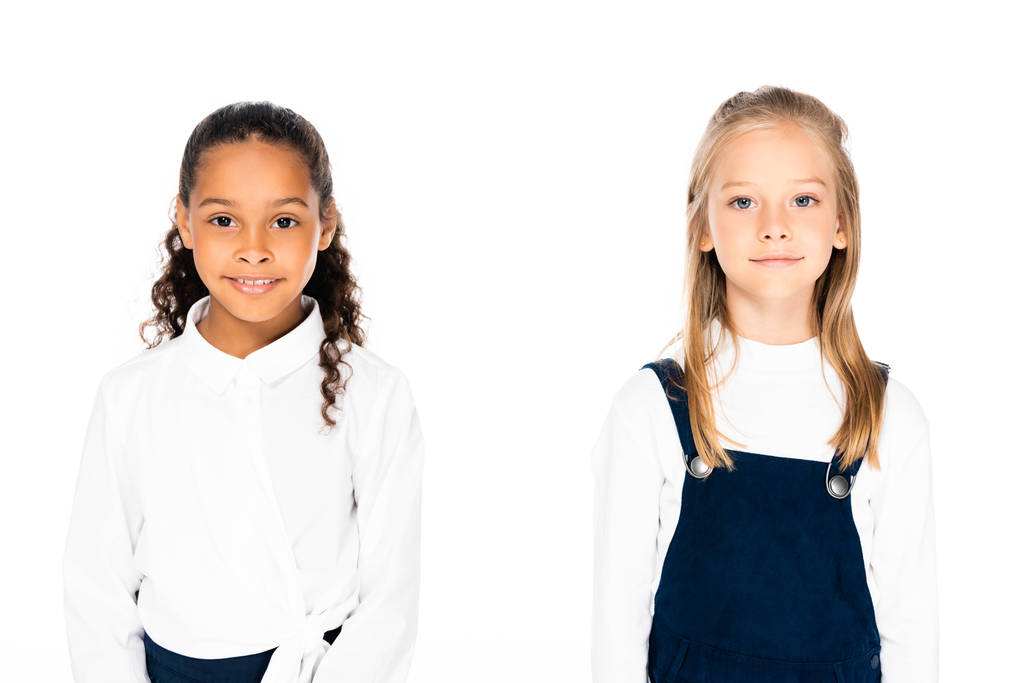 дві чарівні мультикультурні школярки посміхаються на камеру ізольовані на білому
 - Фото, зображення